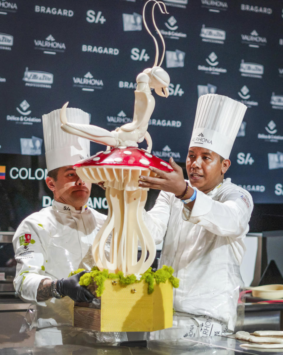 Carlos De Avila, left, and Deiby Sanchez, of Colombia, place their dessert display on a counter during the Coupe de Monde de la Patisserie, or World Pastry Cup, at the Ernest N. Morial Convention Center in New Orleans, Tuesday, June 11, 2024. (Matthew Perschall/The Times-Picayune/The New Orleans Advocate via AP)