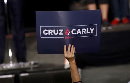 A supporter of Republican U.S. presidential candidate Ted Cruz holds up a new campaign sign reflecting his choice of Carly Fiorina as his running mate at a campaign rally in Indianapolis, Indiana, United States April 27, 2016. REUTERS/Aaron P. Bernstein