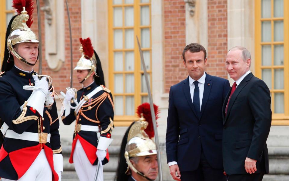 Russian President Vladimir Putin is welcomed by French President Emmanuel Macron at the Versailles Palace - Credit: GEOFFROY VAN DER HASSELT/AFP