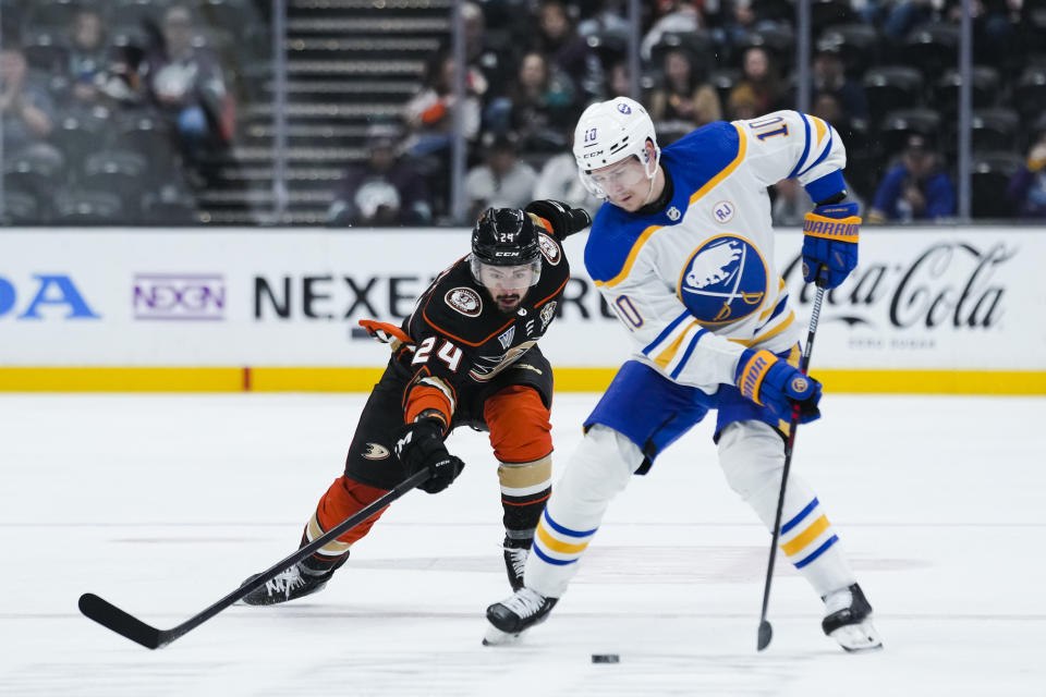 Anaheim Ducks center Bo Groulx, left, lunges for the puck past Buffalo Sabres defenseman Henri Jokiharju during the first period of an NHL hockey game Tuesday, Jan. 23, 2024, in Anaheim, Calif. (AP Photo/Ryan Sun)