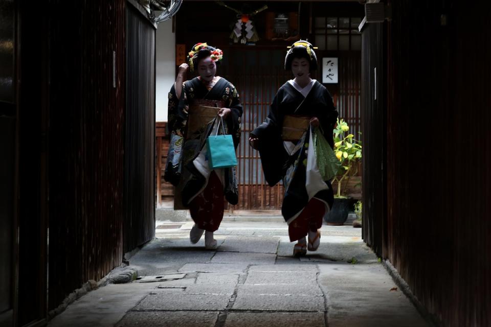 Japanese traditional female dancers, maikos, and performers, geikos leave after attending the new year’s ceremony at the Gion Kobu Kaburenjo Theater in Kyoto (Getty Images)