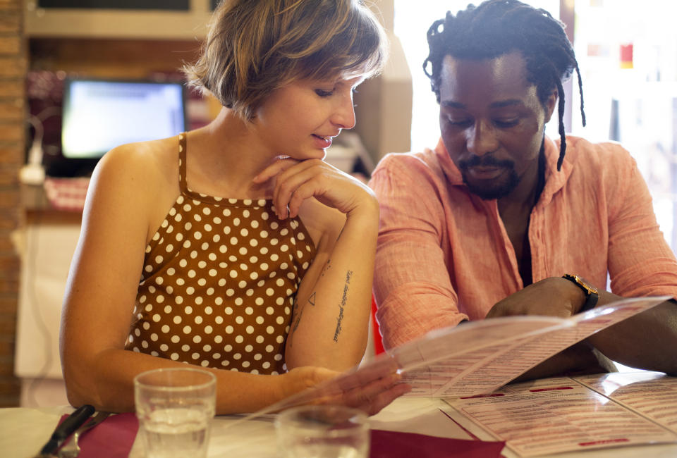 couple in a restaurant looking at a menu