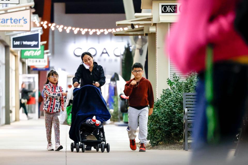 Elena Garcia walks with her children through the OKC Outlet Mall after shopping.