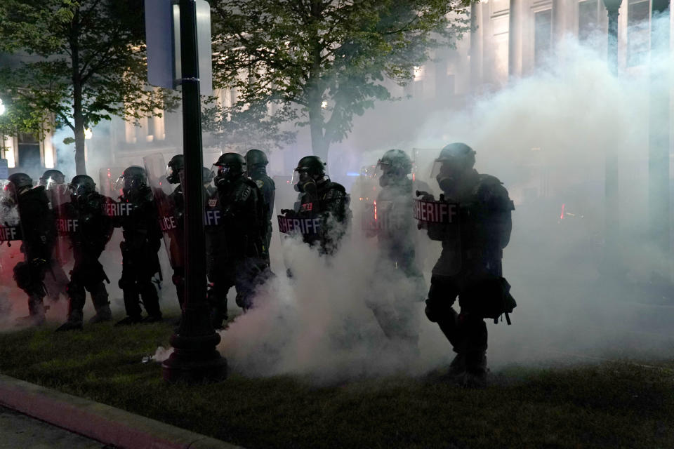 Police clear a park during clashes with protesters outside the Kenosha County Courthouse late Tuesday, Aug. 25, 2020, in Kenosha, Wis., during demonstrations over the Sunday shooting of Jacob Blake. (AP Photo/David Goldman)