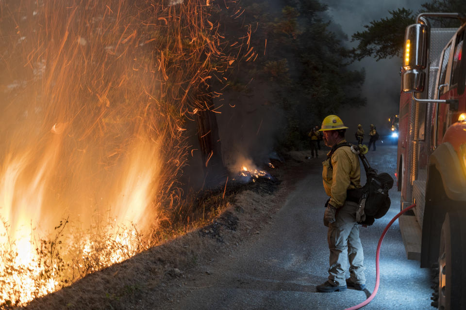 Firefighters monitor a controlled burn along Nacimiento-Fergusson Road to help contain the Dolan Fire near Big Sur, Calif., Friday, Sept. 11, 2020. (AP Photo/Nic Coury)