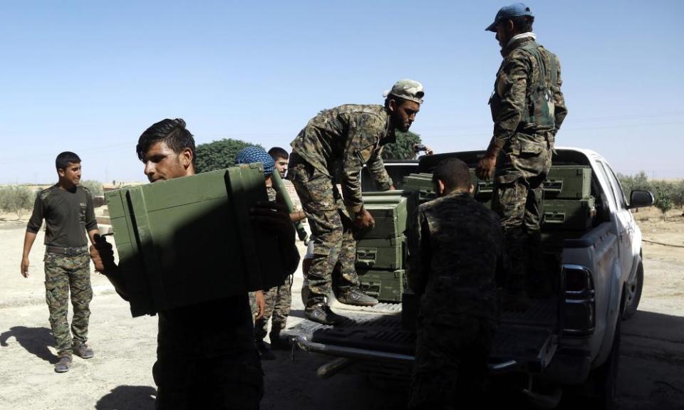 Syrian Democratic Forces (SDF) fighters unload boxes of ammunition supplied by the US-led coalition.