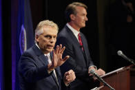 FILE - In this Sept. 16, 2021, file photo, Democratic gubernatorial candidate former Governor, Terry McAuliffe, left, gestures as Republican challenger Glenn Youngkin listens during a debate at the Appalachian School of Law in Grundy, Va. McAuliffe won Virginia's 2013 governor's race by embracing his own brand of personal politics that rely on decades-old friendships, back-slapping charisma and tell-it-like-it-is authenticity. (AP Photo/Steve Helber, File)