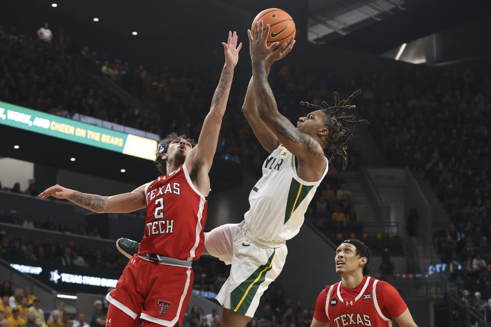 Baylor guard Jayden Nunn (2) shoots over Texas Tech guard Pop Isaacs (2) as Texas Tech guard Darrion Williams (5) looks on during the first half of an NCAA college basketball game Tuesday, Feb. 6, 2024, in Waco, Texas. (AP Photo/Jerry Larson)