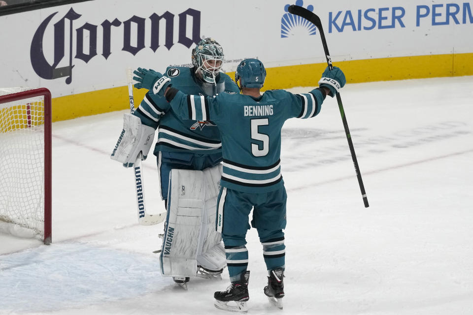 San Jose Sharks goaltender Kaapo Kahkonen, left, celebrates with defenseman Matt Benning (5) after the Sharks defeated the Vancouver Canucks in an NHL hockey game in San Jose, Calif., Saturday, Nov. 25, 2023. (AP Photo/Jeff Chiu)