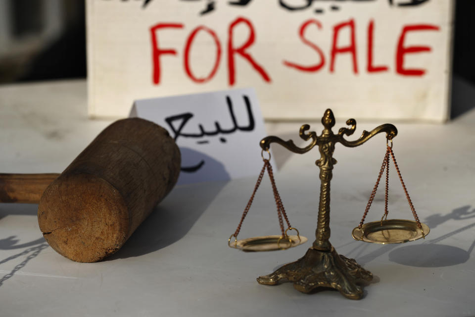 Lebanese activists display symbols of justice during a protest against the slow pace of the investigation into the August 4 explosion that hit Beirut's seaport, outside the Justice Palace, in Beirut, Lebanon, Dec. 3, 2020. The blast was one of the largest non-nuclear explosions in history and six months later, political and confessional rivalries have undermined the probe into the Beirut port explosion and brought it to a virtual halt, mirroring the same rivalries that have thwarted past attempts to investigate political crimes throughout Lebanon's history. (AP Photo/Hussein Malla)