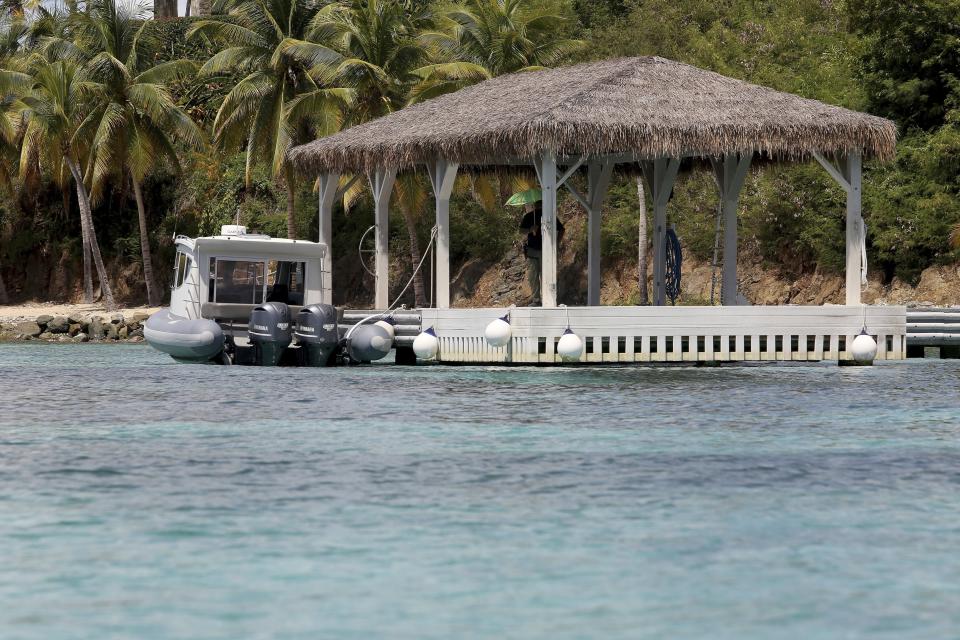 A security guard stands watch in a gazebo on Little St. James Island, in the U. S. Virgin Islands, a property owned by Jeffrey Epstein, Wednesday, Aug. 14, 2019. Armed guards and the sharp rocks that lie beneath the turquoise waters around his Caribbean island have long deterred boaters from the area, but curiosity has overcome concern ever since the financier apparently killed himself in jail as he awaited trial in New York on sex trafficking charges. (AP Photo/Gabriel Lopez Albarran)