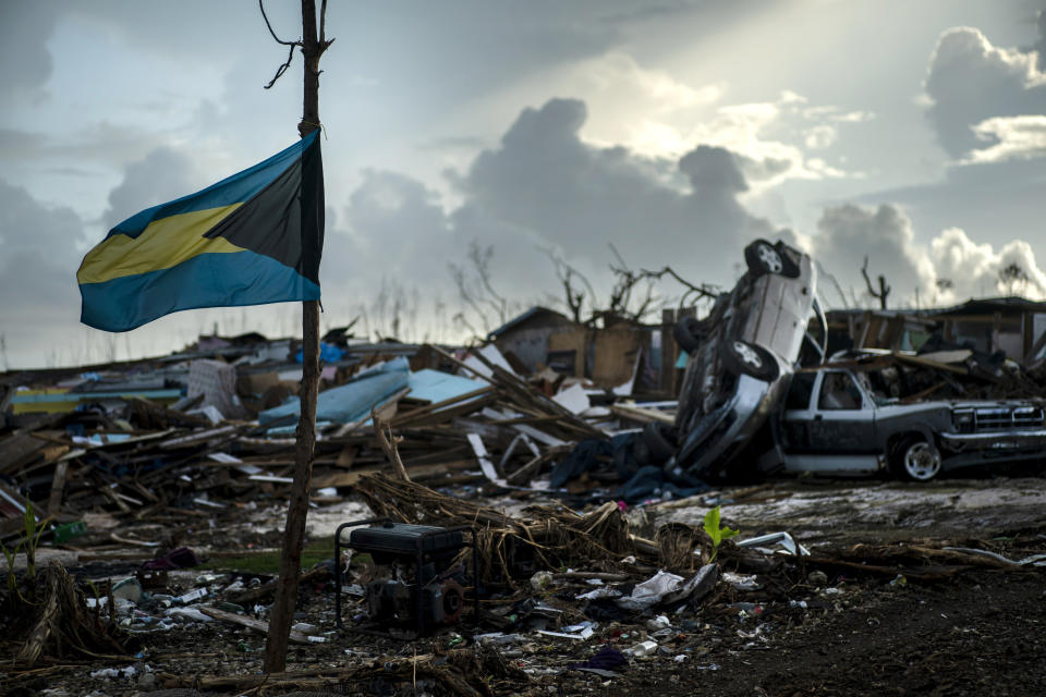 A Bahamas flag flies tied to a sapling, amidst the rubble left by Hurricane Dorian in Abaco, Bahamas, Monday, Sept. 16, 2019. Dorian hit the northern Bahamas on Sept. 1, with sustained winds of 185 mph (295 kph), unleashing flooding that reached up to 25 feet (8 meters) in some areas. (AP Photo/Ramon Espinosa)