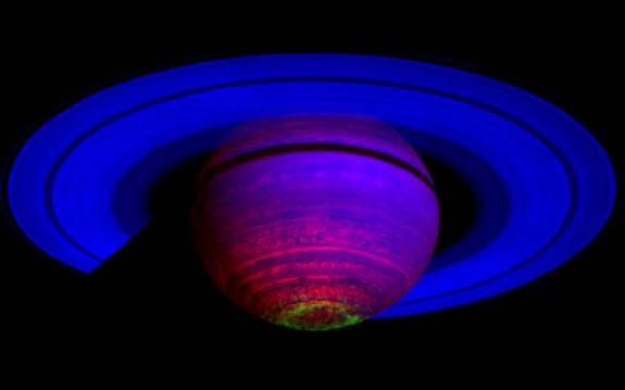 Composite image of Saturn shows the entire planet, including the rings as seen by NASA's Cassini spacecraft from the south. The green glow represents aurora lights. 