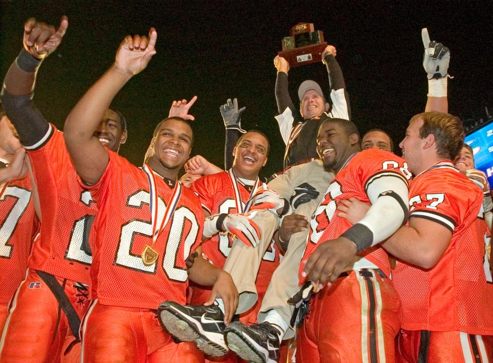 Lakeland High School head coach Bill Castle is hoisted on players' shoulders while after beating St. Thomas Aquinas 45-42 in two overtimes at Dolphin Stadium in Miami in 2006. Lakeland won the state title and national title that year, with Castle's son, Blair, at quarterback.