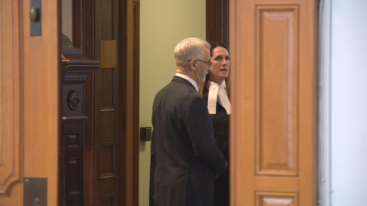 Defence lawyer Rosellen Sullivan and her client, Robert Regular, 72, speak at Supreme Court in St. John's on Monday.  (Mike Simms/CBC - image credit)