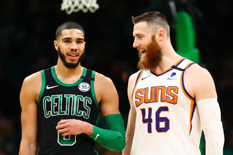 Former teammates Aron Baynes of the Phoenix Suns and Jayson Tatum of the Boston Celtics talk during a game.