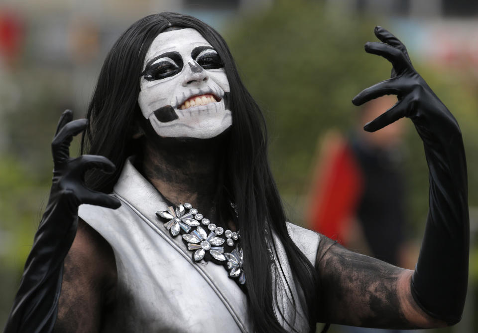 A performer poses for a photo during the Day of the Dead parade in Mexico City, Saturday, Nov. 2, 2019. (AP Photo/Ginnette Riquelme)