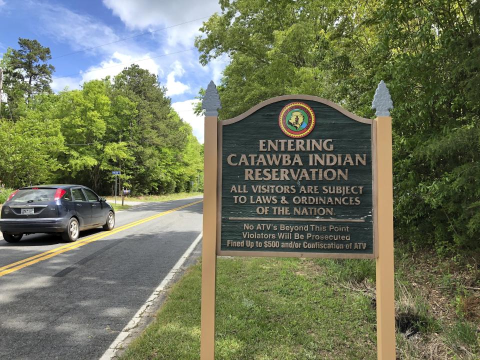 In a Friday, April 26, 2019 photo, a sign welcomes people to the Catawba Indian Nation’s reservation near Rock Hill, S.C. Two of the Carolinas’ most prominent American Indian tribes are battling over geography and lucrative gambling turf. The Cherokee in North Carolina, with two casinos established in the mountains, say their opponents should stay in their own state to the south. The Catawba of South Carolina argue such state boundaries are artificial and shouldn’t affect their effort to gain a foothold in the industry. (AP Photo /Jeffrey Collins)