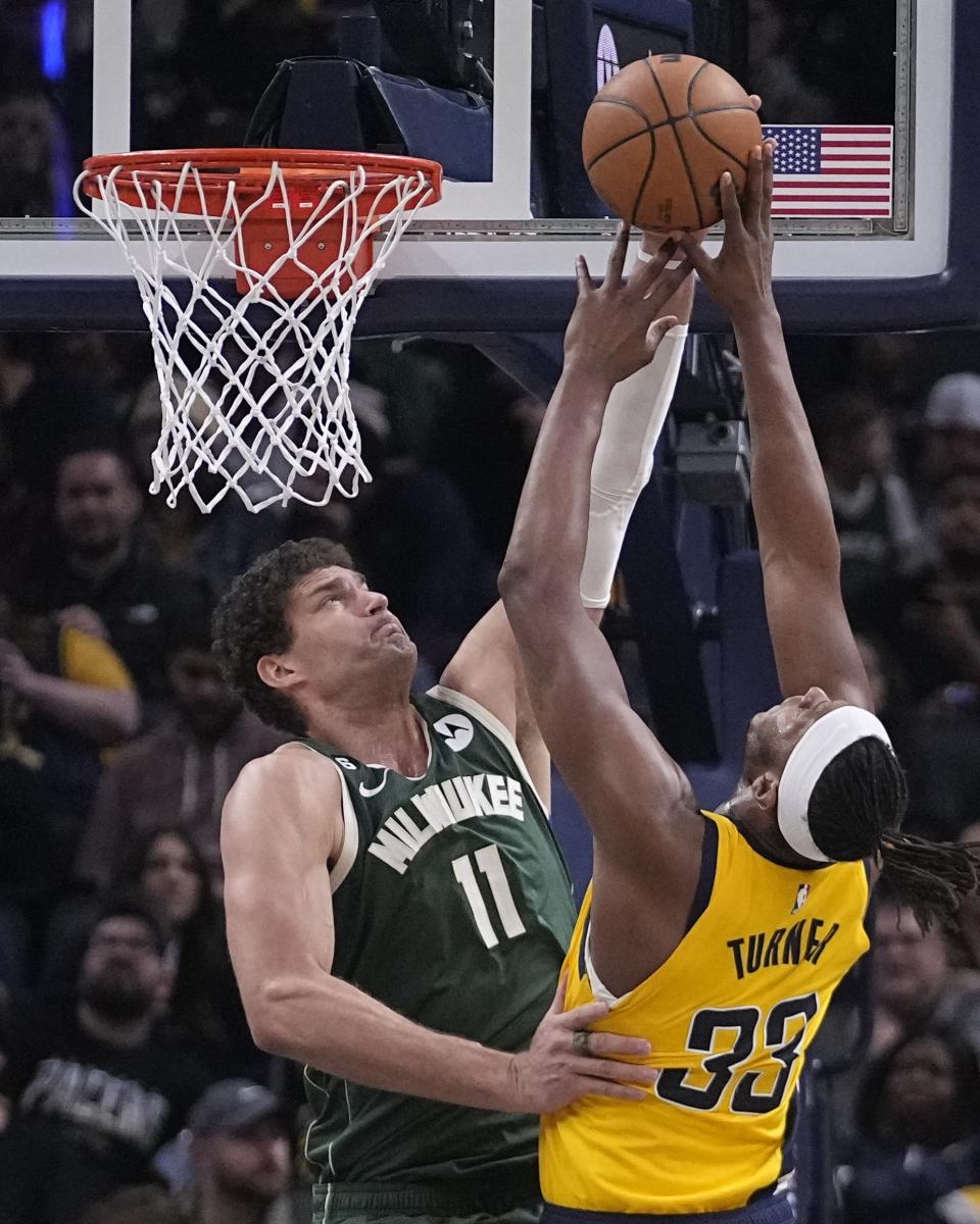 Indiana Pacers' Myles Turner (33) has his shot blocked by Milwaukee Bucks' Brook Lopez (11) during the second half of an NBA basketball game, Friday, Jan. 27, 2023, in Indianapolis. (AP Photo/Darron Cummings)