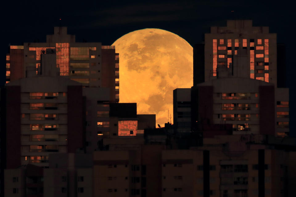 The moon is partially covered by buildings in Brasilia, Brazil, at the start of a total lunar eclipse early Wednesday, May 26, 2021. Wednesday’s eclipse is the first in more than two years and coincides with a supermoon. (AP Photo/Eraldo Peres)