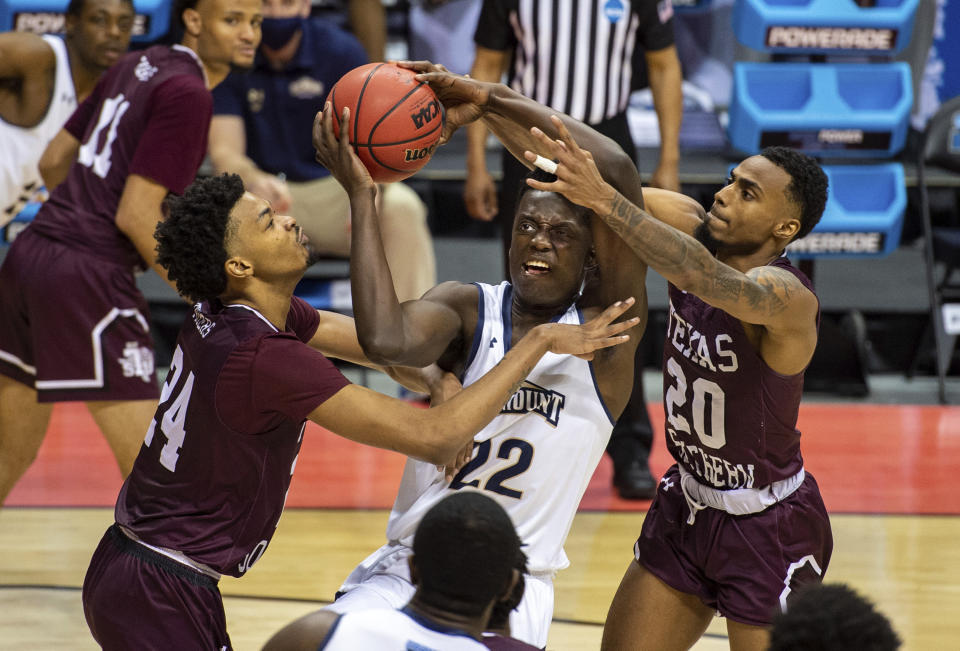 Mount St. Mary's forward Nana Opoku (22) shoots while being defended by Texas Southern forward John Walker III, left, and guard Michael Weathers (20) during the second half of a First Four game in the NCAA men's college basketball tournament Thursday, March 18, 2021, in Bloomington, Ind. (AP Photo/Doug McSchooler)