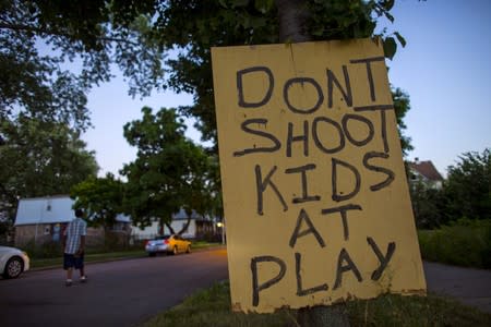 FILE PHOTO: A man walks down a street past a handmade sign posted in the Englewood neighborhood in Chicago