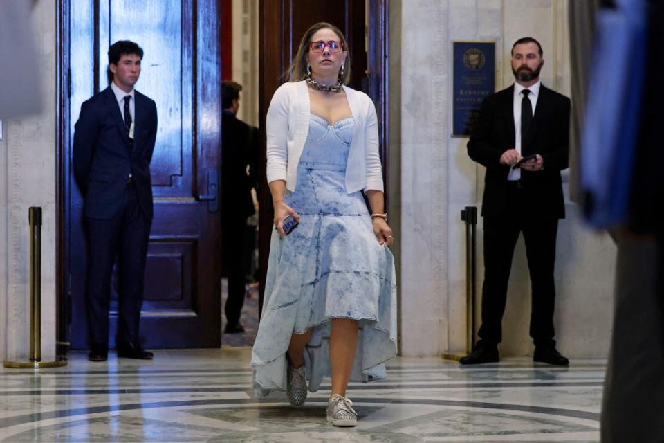 Kyrsten Sinema wears an acid-wash denim dress and silver shoes