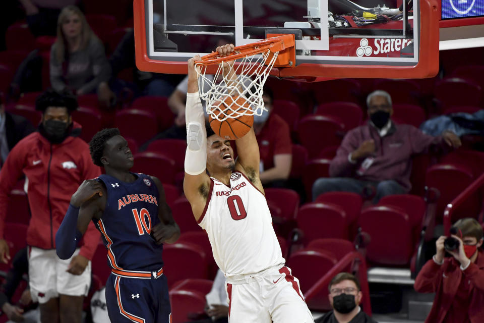 Arkansas forward Justin Smith (0) dunks in front of Auburn defender JT Thor (10) during the second half of an NCAA college basketball game Wednesday, Jan. 20, 2021, in Fayetteville, Ark. (AP Photo/Michael Woods)