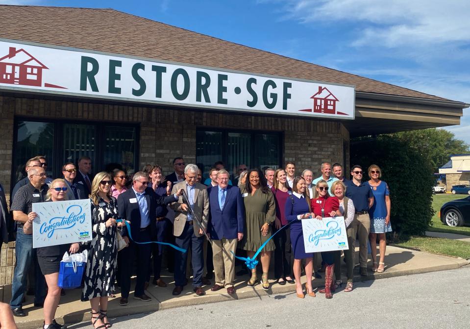 The Restore SGF board, members of Springfield City Council and supporters cut the ribbon at the new Restore SGF offices at 1409 W. Sunshine St. on Wednesday, Sept. 13, 2023. The nonprofit launched its first program aimed at restoring homes in historic neighborhoods.
