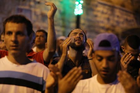 Palestinian men take part in evening prayers inside Jerusalem's Old City, next to the Lion's Gate, July 24, 2017. REUTERS/Ammar Awad