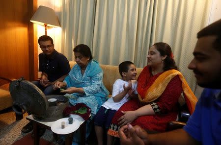 Rehana Khursheed Hashmi, 75 (2nd L) migrated from India with her family in 1960 and whose relatives, live in India, prepares pan (beetle leaf) while sitting with her grandsons and daughter in-law at her residence in Karachi, Pakistan August 7, 2017. REUTERS/Akhtar Soomro