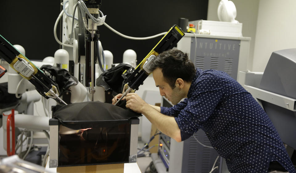 Iranian-born bioengineer researcher Nima Enayati works on a robotic surgery machine during an interview with the Associated Press at the Polytechnic University of Milan, Italy, Tuesday, Jan. 31, 2017. An Iranian researcher at Milan's Polytechnic University, Enayati was refused check-in Monday at Milan's Malpensa Airport for his U.S.-bound flight on Turkish Airlines after the Trump administration's executive order came down. (AP Photo/Luca Bruno)