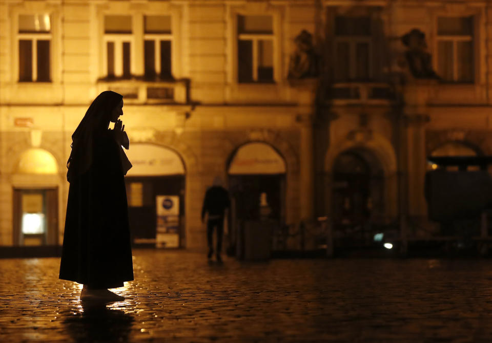 A nun prays on the near empty Old Town Square in Prague, Czech Republic, Friday, Oct. 23, 2020. (AP Photo/Petr David Josek)