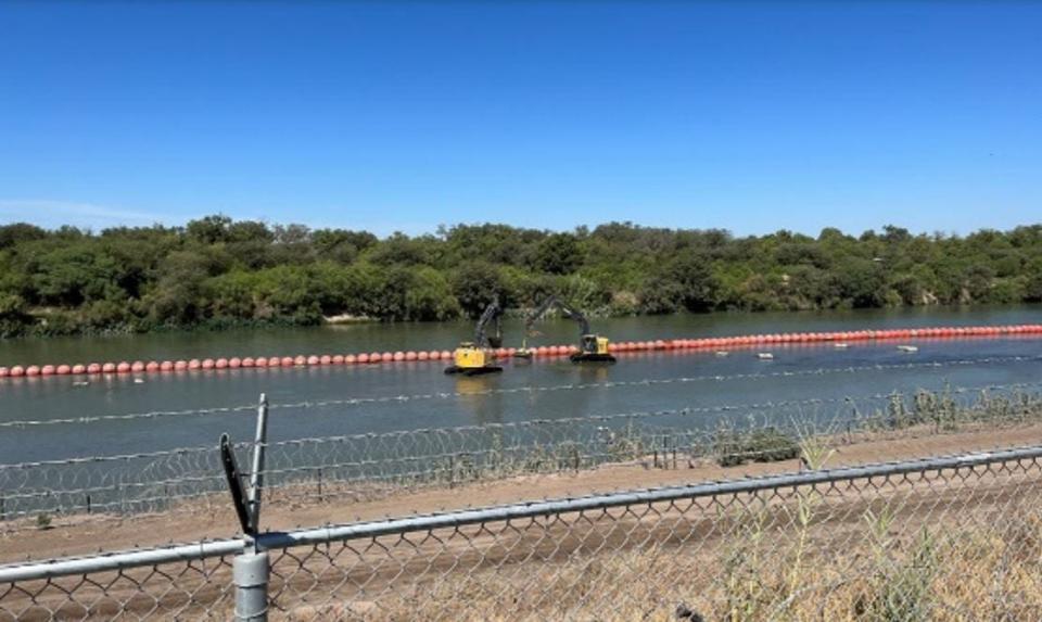 This photo taken Aug. 18, 2023, by an engineer with the International Boundary and Water Commission shows heavy equipment repositioning Texas' buoy chain from Mexican territory to the U.S. side of the Rio Grande.