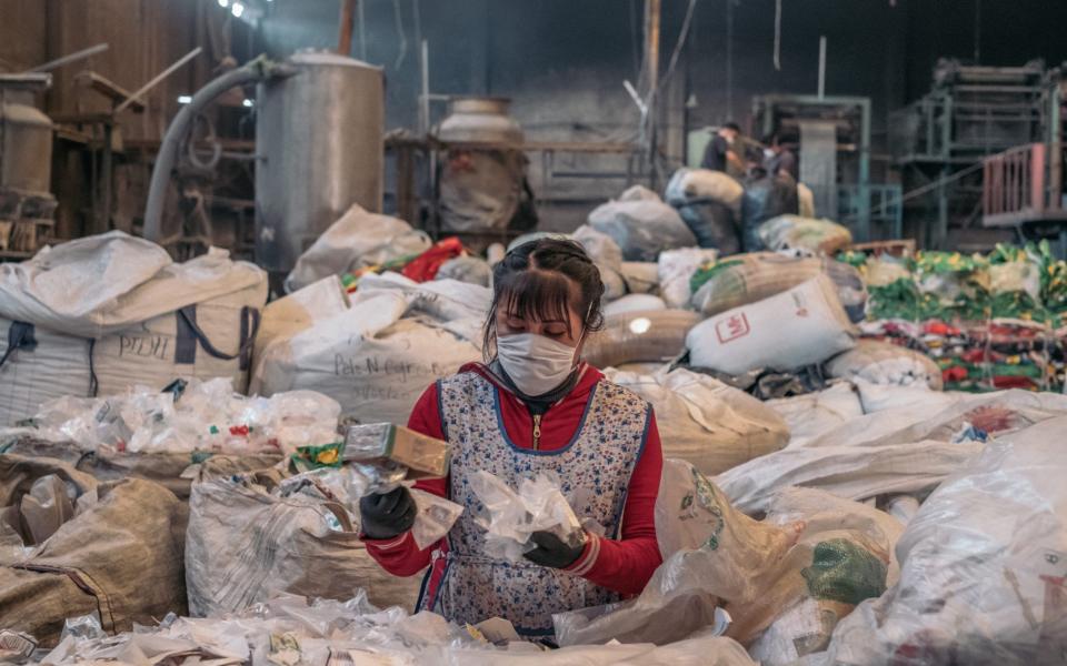 A worker wearing a protective mask sorts plastic at the United Plastic Bag Recyclers (Ruboplast) manufacturing facility in Ecatepec, Mexico State, Mexico - Bloomberg