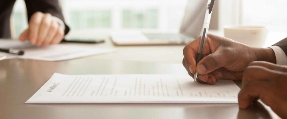 Horizontal close up photo african businessman signing loan.