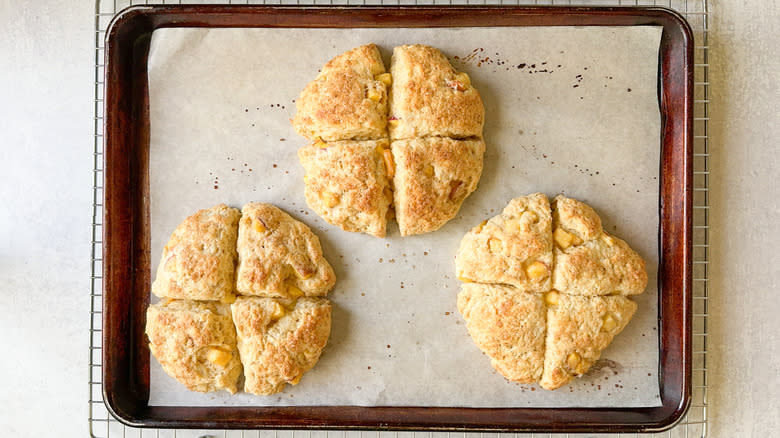 Peaches and cream scones cooling on baking sheet on rack