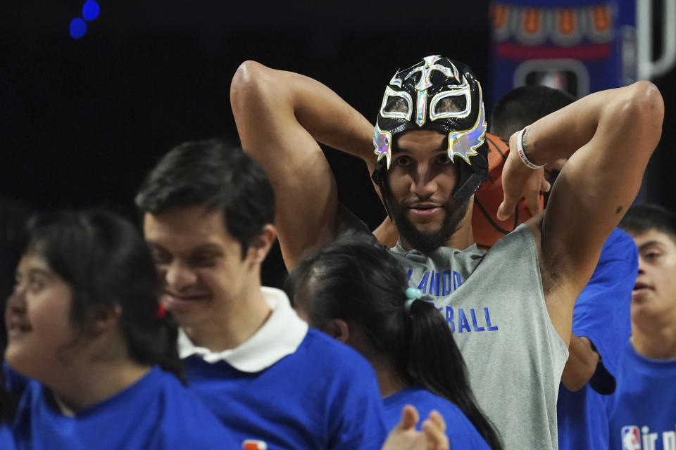 Orlando Magic's Jalen Suggs wears a Lucha Libre wrestling mask as he attends an event with children with down syndrome on the sidelines of training at the CDMX Arena in Mexico City, Wednesday, Nov. 8, 2023. Orlando Magic will face The Atlanta Hawks in an NBA basketball game on Nov. 9. (AP Photo/Marco Ugarte)