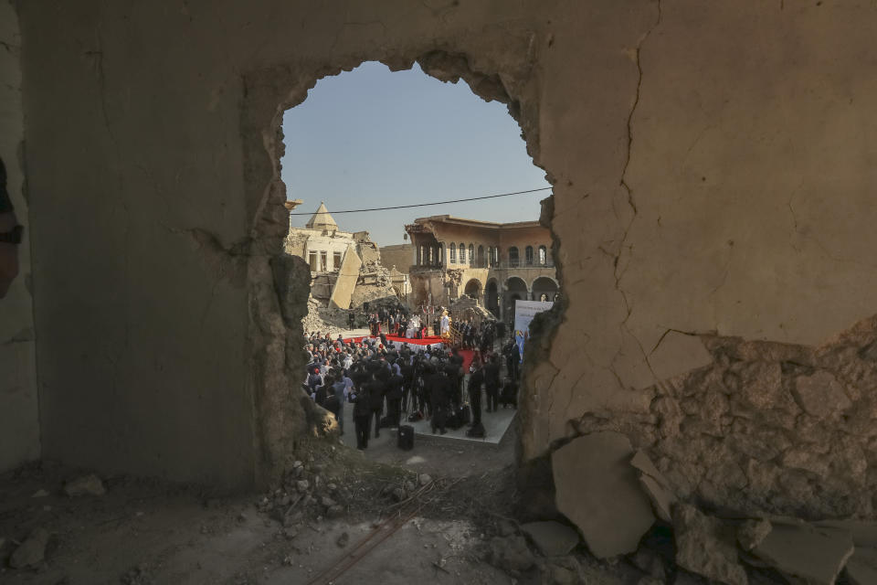 Pope Francis, surrounded by shells of destroyed churches, attends a prayer for the victims of war at Hosh al-Bieaa Church Square, in Mosul, Iraq, once the de-facto capital of IS, Sunday, March 7, 2021. The long 2014-2017 war to drive IS out left ransacked homes and charred or pulverized buildings around the north of Iraq, all sites Francis visited on Sunday. (AP Photo/Andrew Medichini)