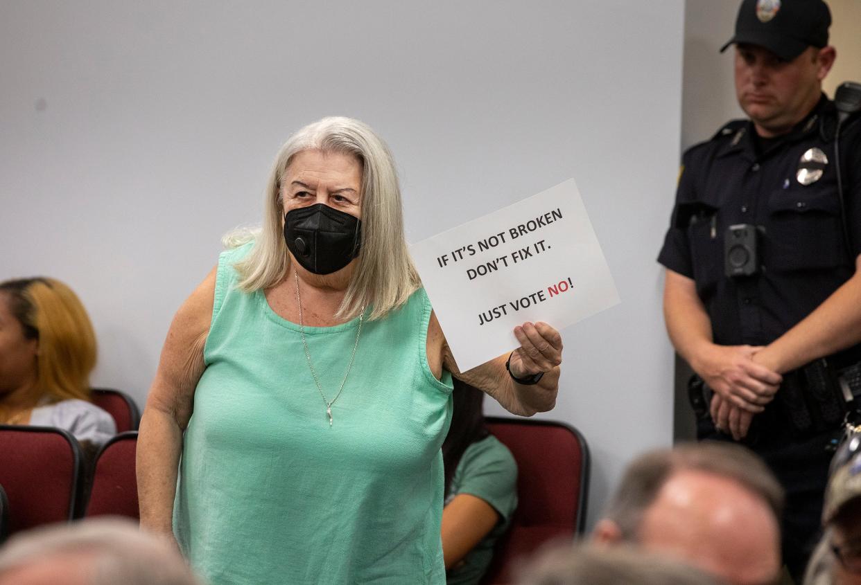 Lake Wales resident Juanita Zwaryczuk holds up a sign during a City Commission meeting on Tuesday night. She was one of many speakers who criticized a resolution setting a time limit for public comments at meetings.