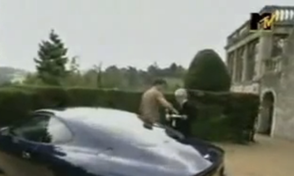 Frame from MTV Cribs UK showing Robbie Williams outside with his car and butler