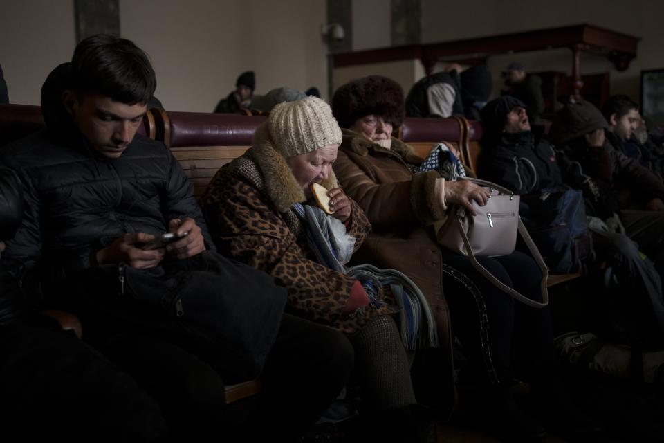 A Ukrainian elderly woman eats a slice of bread inside a crowded railway station, Feb. 28, 2022, in Lviv, west Ukraine. The image was part of a series of images by Associated Press photographers that was a finalist for the 2023 Pulitzer Prize for Feature Photography. (AP Photo/Bernat Armangue)