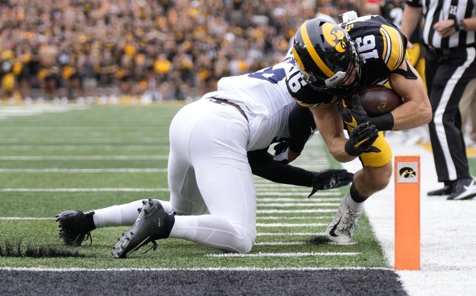 Iowa wide receiver Charlie Jones (16) dives in for a touchdown despited defensive efforts by Penn State safety Ji'Ayir Brown (16) during the first half of an NCAA college football game, Saturday, Oct. 9, 2021, in Iowa City, Iowa. (AP Photo/Matthew Putney)