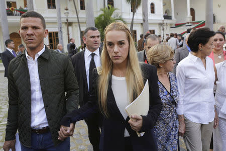 FILE PHOTO: Lilian Tintori (C), wife of jailed opposition leader Leopoldo Lopez, holds hands with opposition deputy Gilbert Caro (L) as she leaves after a meeting with deputies of the Venezuelan coalition of opposition parties (MUD) and relatives of imprisoned dissidents at the National Assembly in Caracas, January 11, 2016. REUTERS/Marco Bello/File Photo