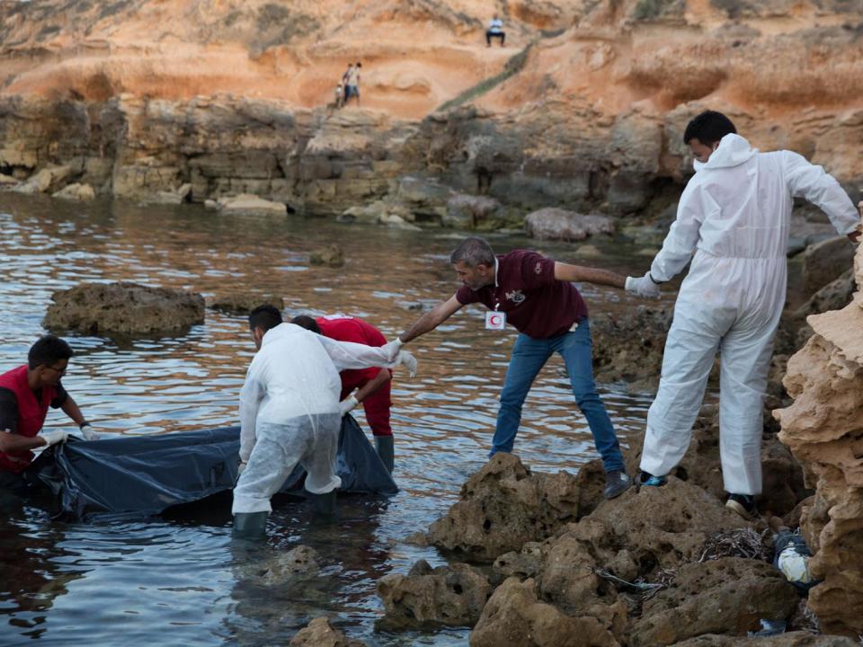 Members of the Libyan Red Crescent recover bodies of migrants washed ashore near Tripoli, Libya, on 27 June (EPA)