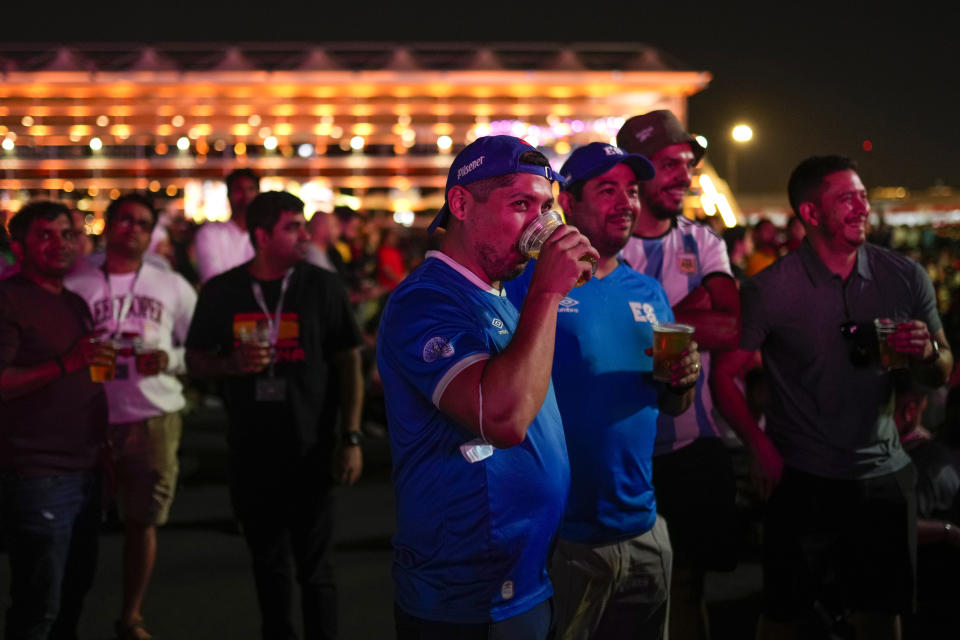 FILE - People drink beers as they watch in a giant screen at the fan zone the World Cup group A soccer match between Qatar and Ecuador being played at the Al Bayt stadium in Al Khor, in Doha, Qatar, Sunday, Nov. 20, 2022. (AP Photo/Francisco Seco, File)