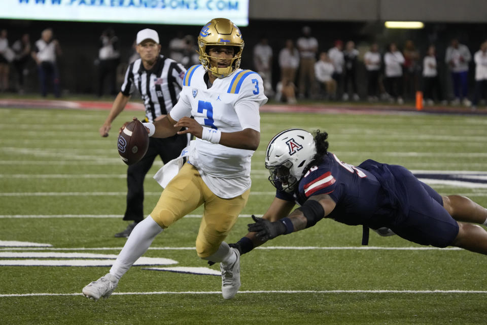 UCLA quarterback Dante Moore (3) runs away from Arizona defensive lineman Nick Fernandez during the second half of an NCAA college football game Saturday, Nov. 4, 2023, in Tucson, Ariz. (AP Photo/Rick Scuteri)