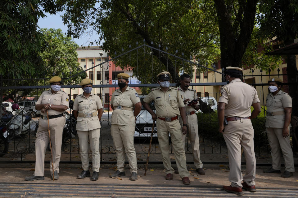 Police officers stand guard at a gate of the Mahatma Gandhi Memorial college after hijab wearing Muslim girl students were denied entry into the campus in Udupi, Karnataka state, India, Feb. 24, 2022. To quell tensions the Karnataka state, governed by Prime Minister Narendra Modi's Bharatiya Janata Party, shut schools and colleges for three days. It then slapped a statewide ban on the hijab in classes, saying "religious clothing" in government-run schools "disturbs equality, integrity and public law and order." (AP Photo/Aijaz Rahi)