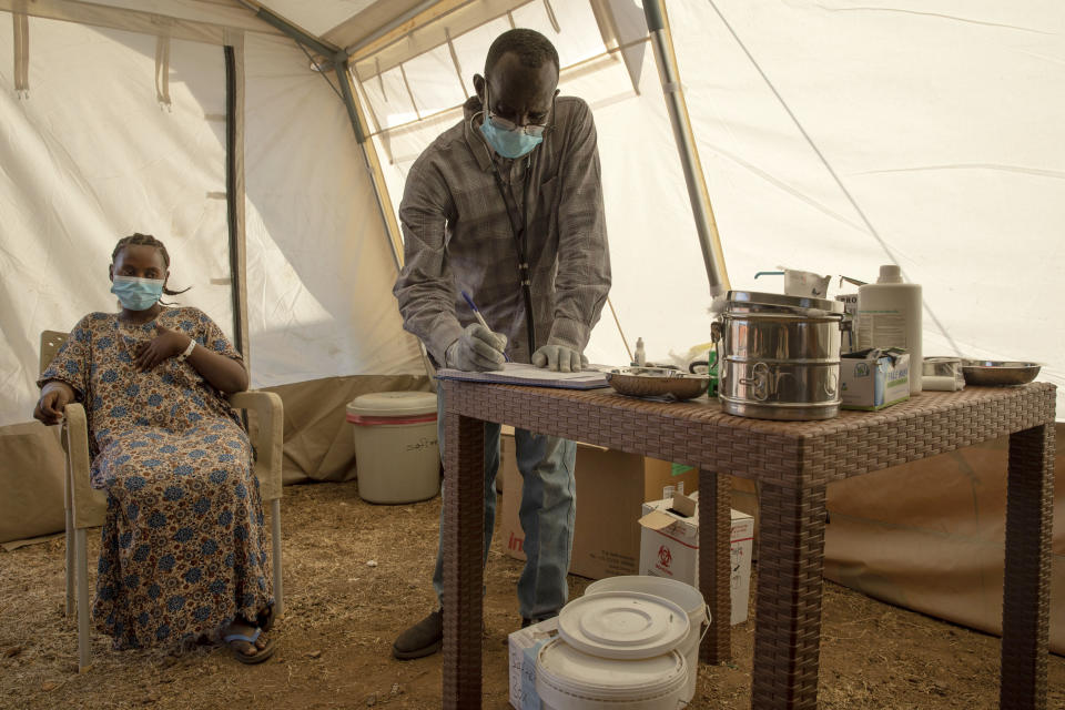 A Tigray woman who fled the conflict in Ethiopia's Tigray region, holds her chest as she suffers from chest pains and coughs, at the Medecins Sans Frontieres (MSF) makeshift clinic, in Umm Rakouba refugee camp in Qadarif, eastern Sudan, Tuesday, Nov. 24, 2020. Misery continues for the refugees in Sudan, with little food, little medicine, little shelter, little funding and little or no contact with loved ones left behind in Tigray. (AP Photo/Nariman El-Mofty)