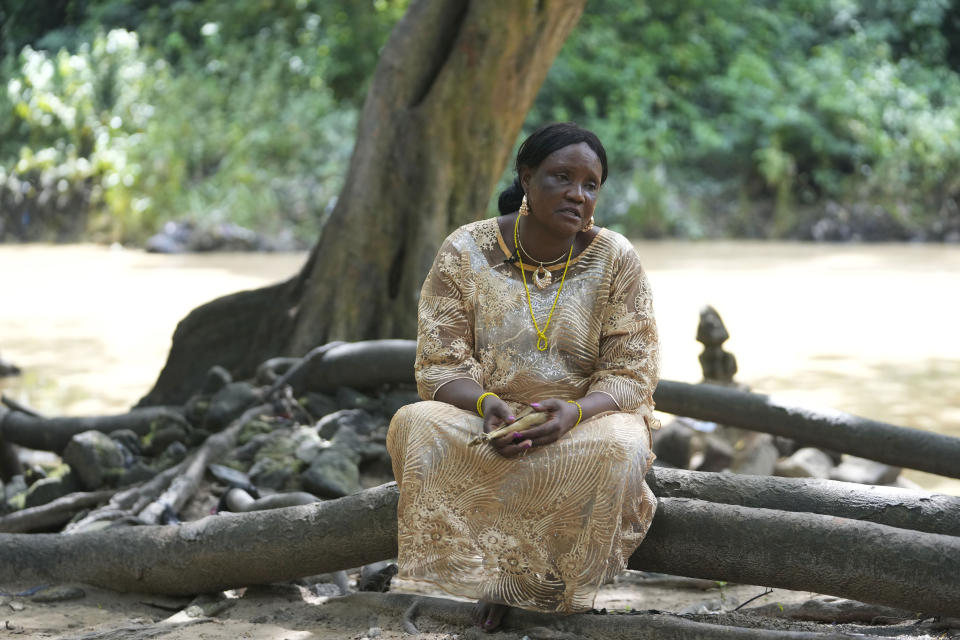Priestess Yeyerisa Abimbola speaks during an interview at the sacred Osun River in Osogbo, Nigeria, on Sunday, May 29, 2022. She has dedicated most of her 58 years on Earth to the Osun, a waterway in deeply religious Nigeria named for the river goddess of fertility. But with each passing day, she worries more and more about the river. “The problem we face now are those that mine by the river,” Abimbola said. “As you can see, the water has changed color.” (AP Photo/Sunday Alamba)
